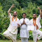 Yoga graduates celebrating certification with instructor in Rishikesh, India.